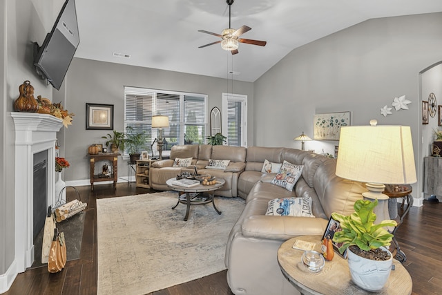 living room featuring dark hardwood / wood-style flooring, lofted ceiling, and ceiling fan