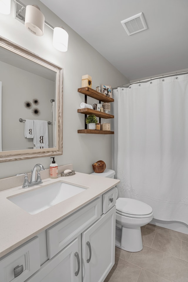 bathroom featuring tile patterned flooring, vanity, and toilet