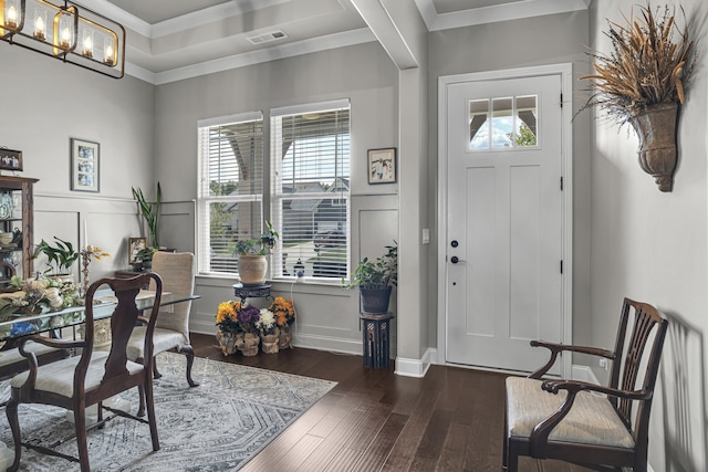 entrance foyer featuring ornamental molding, dark hardwood / wood-style floors, and an inviting chandelier