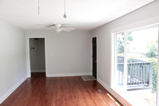 unfurnished room featuring dark wood-type flooring, a textured ceiling, and ceiling fan