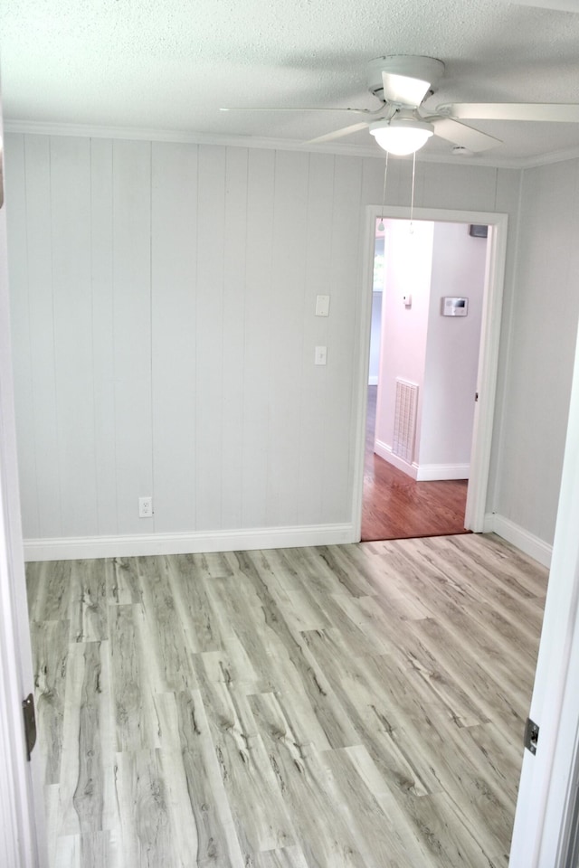 unfurnished room featuring light hardwood / wood-style flooring, a textured ceiling, and ceiling fan