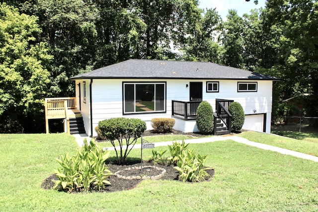 ranch-style home with a garage, a front yard, and a deck