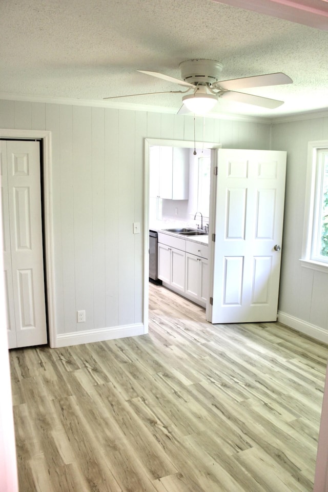 interior space with a textured ceiling, light hardwood / wood-style flooring, and sink