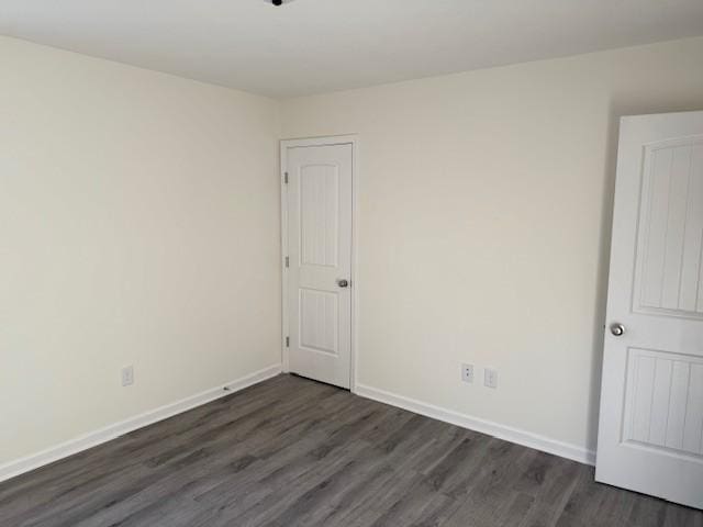 empty room with dark hardwood / wood-style flooring