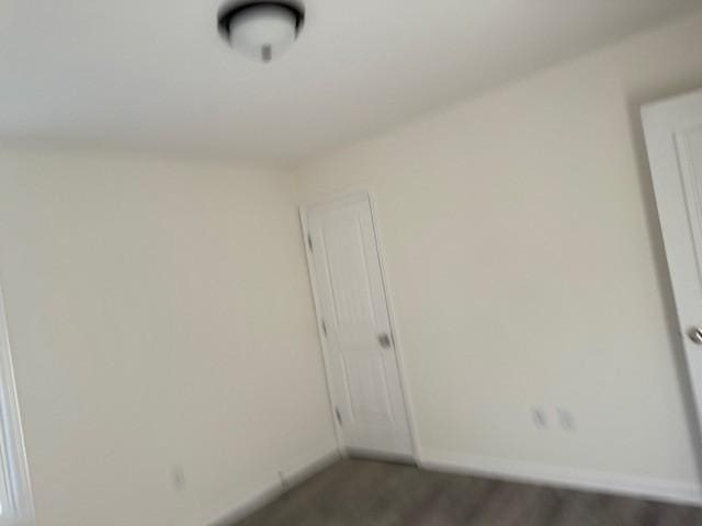 empty room with dark hardwood / wood-style flooring