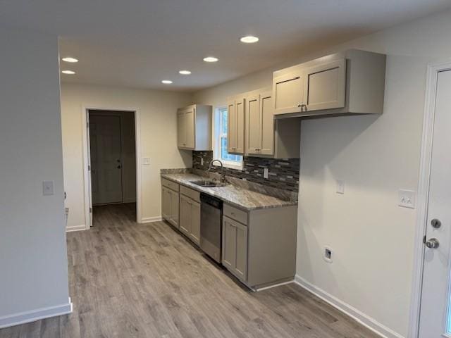 kitchen featuring sink, light stone counters, gray cabinets, dishwasher, and light hardwood / wood-style floors