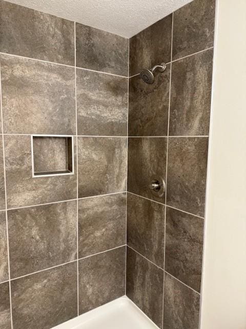 details with tiled shower and a textured ceiling