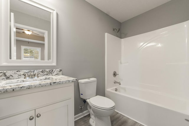 full bathroom with toilet, hardwood / wood-style floors, ceiling fan, shower / bathtub combination, and vanity