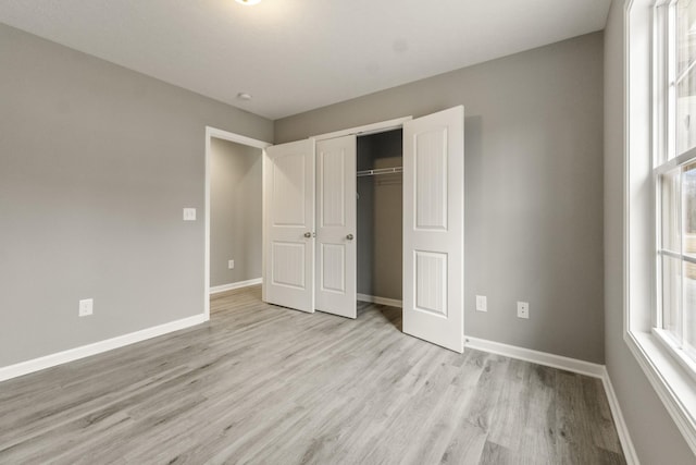 unfurnished bedroom with a closet and light hardwood / wood-style floors