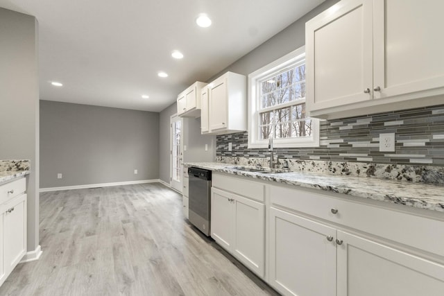 kitchen featuring dishwasher, light hardwood / wood-style floors, light stone countertops, sink, and white cabinetry