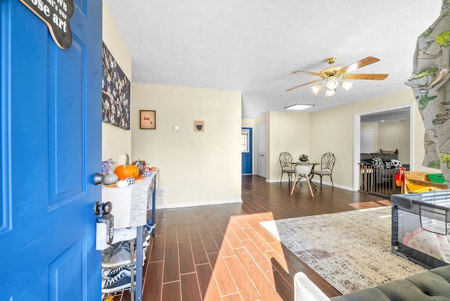 entryway featuring ceiling fan, a textured ceiling, and dark hardwood / wood-style flooring