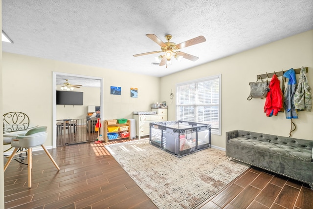 playroom with dark hardwood / wood-style floors and a textured ceiling