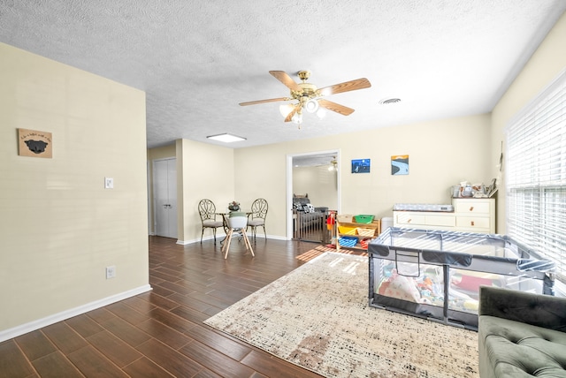 interior space with ceiling fan, a textured ceiling, and dark hardwood / wood-style flooring