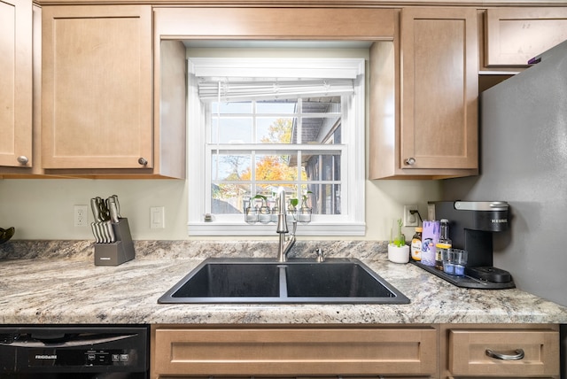 kitchen featuring light stone countertops, sink, light brown cabinets, and dishwasher