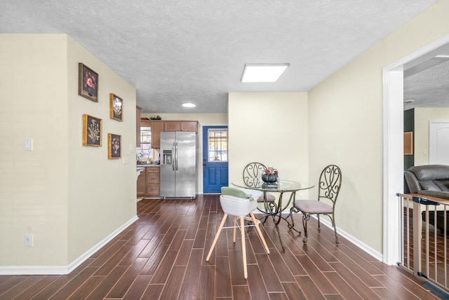 dining area with a textured ceiling and dark hardwood / wood-style floors