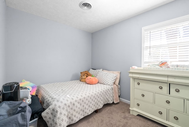 bedroom featuring light carpet and a textured ceiling