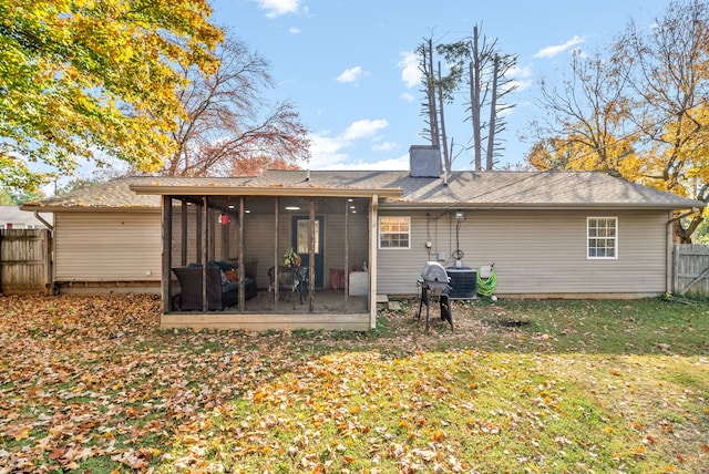 back of property featuring central AC unit, a lawn, and a sunroom