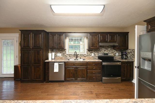 kitchen featuring appliances with stainless steel finishes, hardwood / wood-style floors, tasteful backsplash, and sink