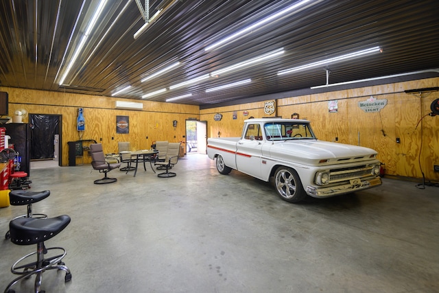 garage with wood walls and a wall mounted AC