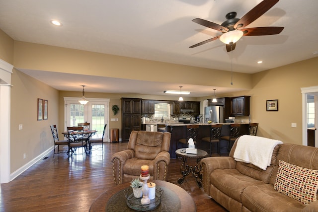 living room with sink, dark wood-type flooring, and ceiling fan