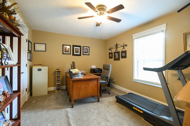 home office with light carpet, a textured ceiling, and ceiling fan