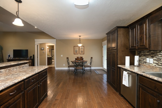 kitchen with dark brown cabinets, backsplash, dishwasher, dark wood-type flooring, and pendant lighting