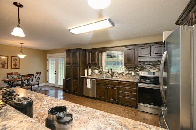 kitchen with a healthy amount of sunlight, appliances with stainless steel finishes, sink, and decorative light fixtures