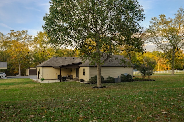 exterior space with a patio, central AC unit, a garage, and a lawn