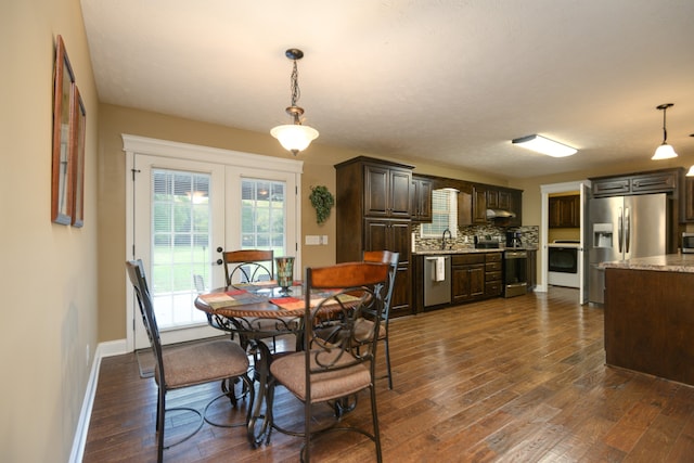 dining room featuring french doors, sink, and dark wood-type flooring