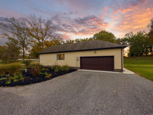 property exterior at dusk featuring a garage and a lawn