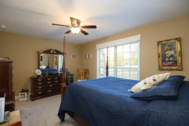 bedroom with a textured ceiling, carpet flooring, and ceiling fan