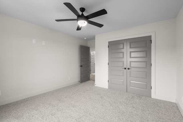 unfurnished bedroom with carpet, ceiling fan, and a closet