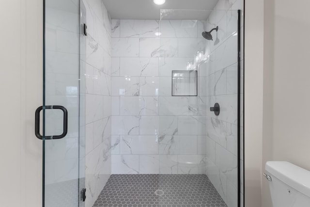 bathroom featuring walk in shower and toilet