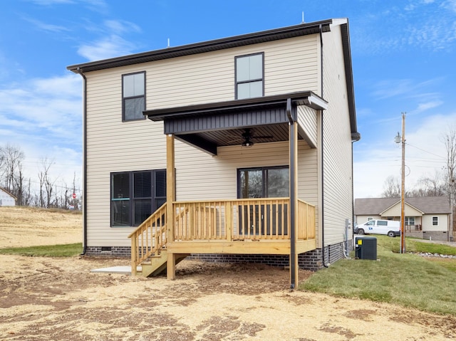 rear view of house featuring central air condition unit, ceiling fan, and a yard