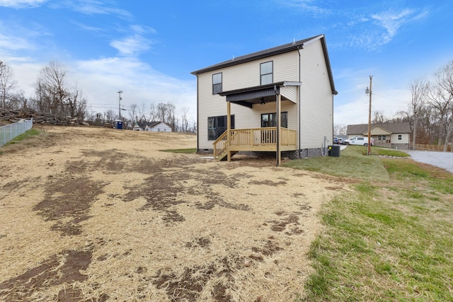 back of property with a lawn and a wooden deck