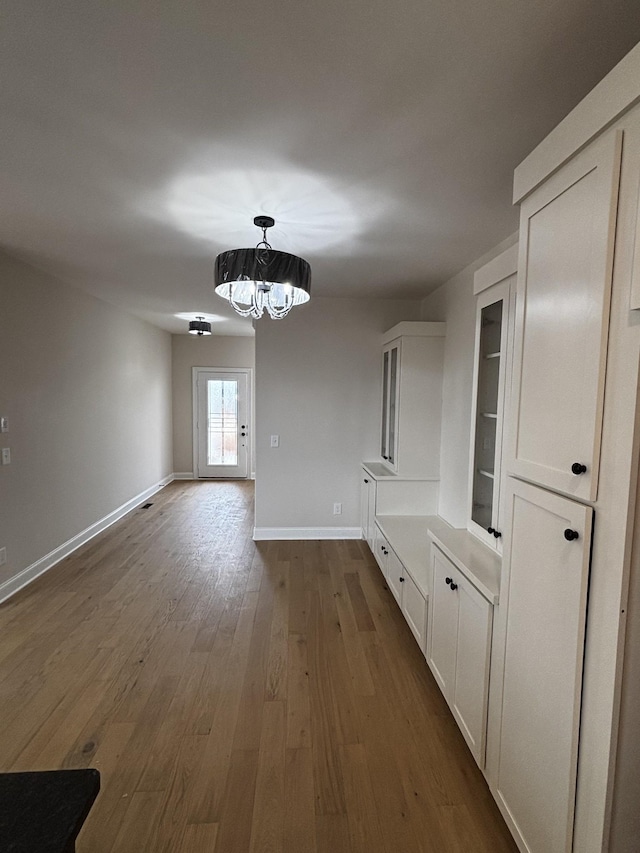 unfurnished dining area with dark hardwood / wood-style floors and a notable chandelier