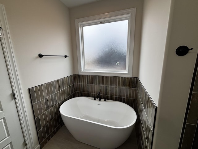 bathroom with a bathtub and tile walls