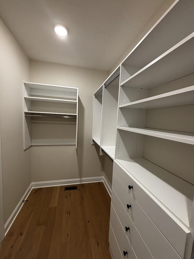 spacious closet with dark wood-type flooring