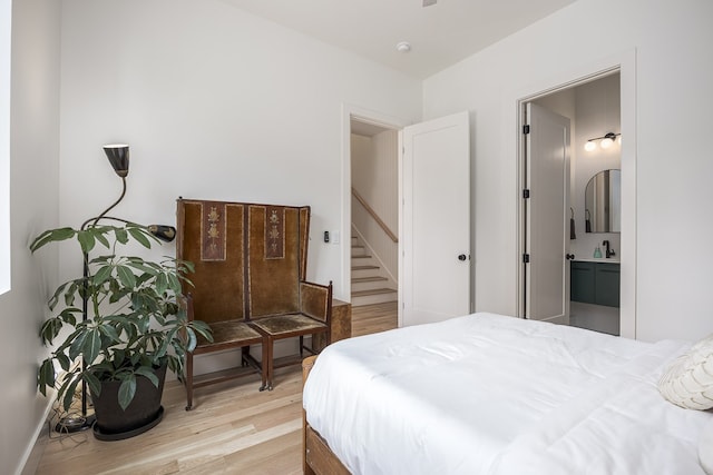 bedroom featuring ensuite bath, sink, and light hardwood / wood-style flooring