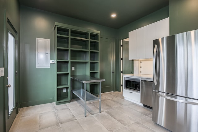 kitchen with electric panel, white cabinets, and stainless steel appliances