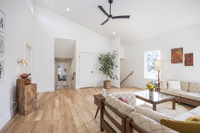 living room featuring ceiling fan, light hardwood / wood-style floors, and high vaulted ceiling