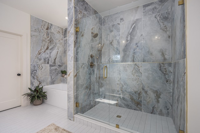 bathroom with tile patterned flooring, tile walls, and independent shower and bath