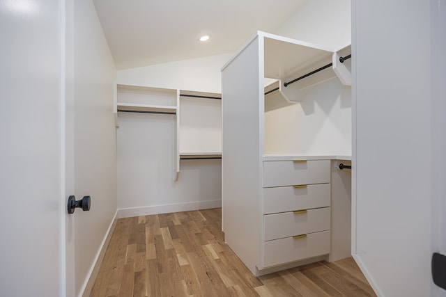 walk in closet featuring light hardwood / wood-style flooring and vaulted ceiling