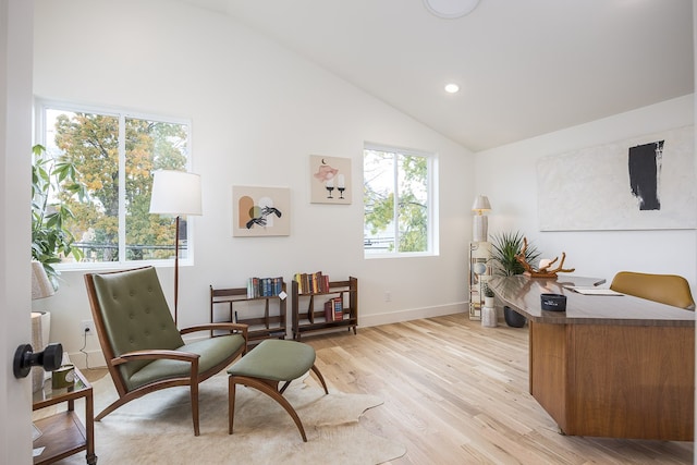 living area with vaulted ceiling, light hardwood / wood-style flooring, and a healthy amount of sunlight