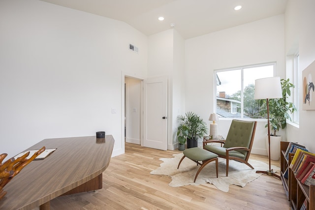 sitting room featuring high vaulted ceiling and light hardwood / wood-style flooring