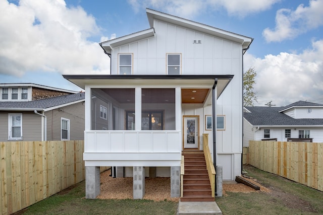 back of property with a sunroom