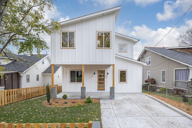 modern inspired farmhouse featuring covered porch and a front lawn