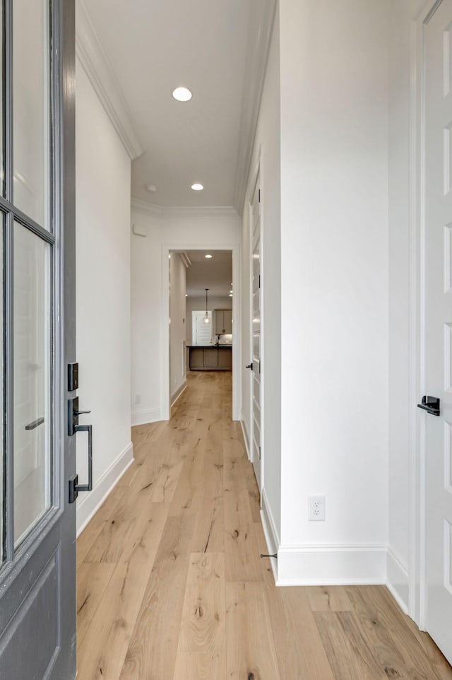 hallway with ornamental molding and light wood-type flooring