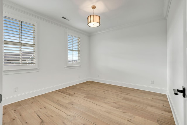 spare room featuring ornamental molding and light wood-type flooring