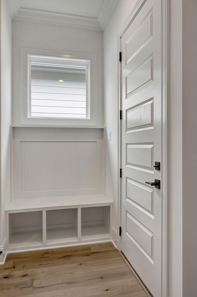 mudroom with ornamental molding and light wood-type flooring